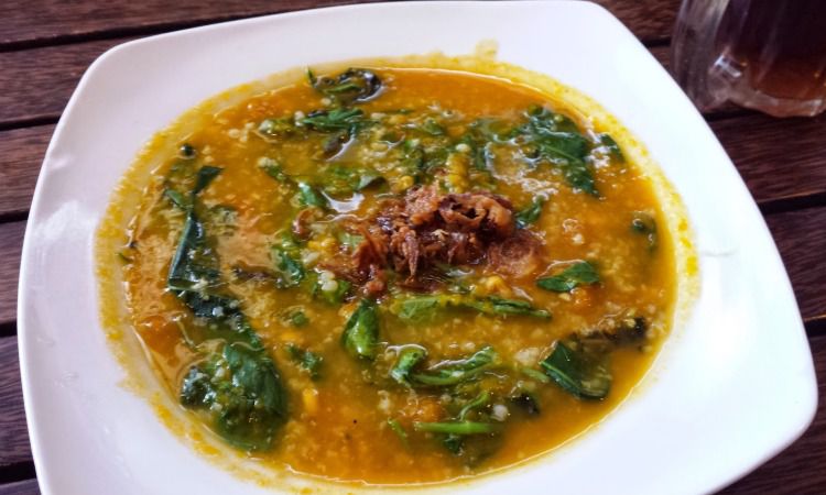 Memakan Bubur Manado Dengan Rasa Pedas